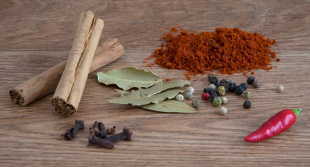 Cinnamon sticks and other spices on a wooden service.