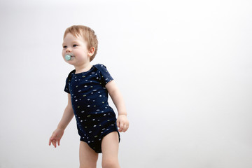 Portrait of boy child standing next to white wall. Lifestyle photo
