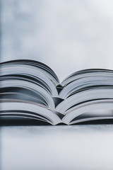 education and self-improvement, pile of open books shot from eye level with shallow depth of field
