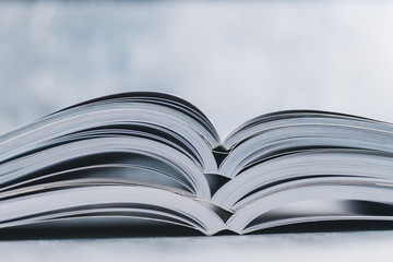 education and self-improvement, pile of open books shot from eye level with shallow depth of field