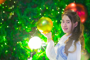 Naklejka premium Beautiful girl with Christmas tree and bokeh