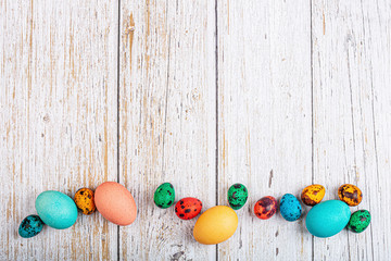 Stylish background with easter eggs with copy space for text on white wooden background. Flat lay, top view, mockup, overhead, template