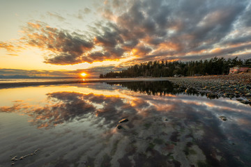 Amazing sunrise cloud reflection along the ocean in Kye bay on Vancouver Island, British Columbia, Canada.