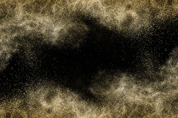 golden powder splash and brush for makeup artist or beauty blogger in black background