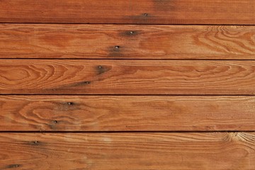 Obraz na płótnie Canvas texture of wood planks covered with glaze, boards are nailed. color similar to chestnut, teak, walnut or oak. May be suitable for advertising protective wood coatings