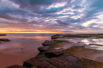 Rock platform at Turimetta Beach, Sydney, during low tide sunrise.