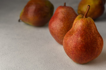 Four ripe red pears on a light background. Selective focus. Copy space. 