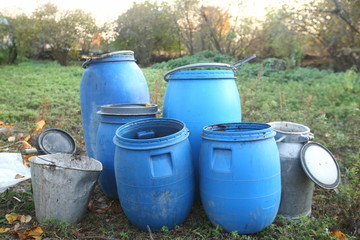 The blue plastic barrels for storage of chemicals . Stockpile of used blue plastic drums for...