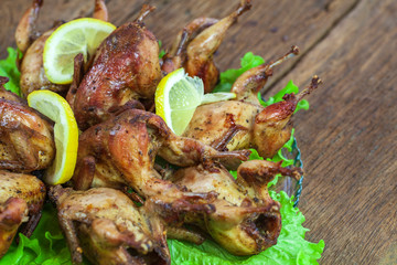 Fried quail in the orange with tomato and fresh parsley and spices