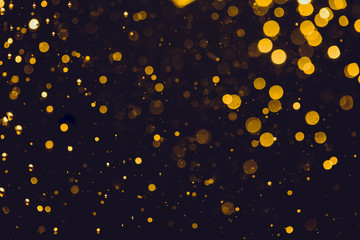 Abstract gold defocused bokeh of lights in dark