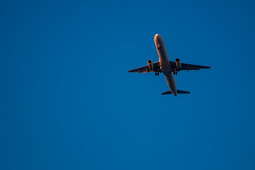 Fototapeta na wymiar A plane flies through the blue sky