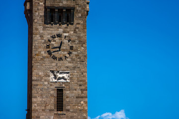 Stone clock tower on a background of blue sky