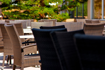 Chairs stand on the terrace against the background of green trees