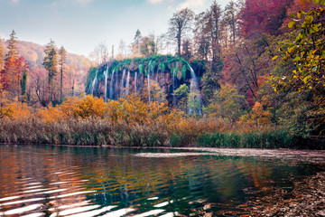 Pure water lake and waterfall in Plitvice National Park. Astonishing autumn landscape of Croatia, Europe. Picturesque outdoor scene of forest in October. Beauty of nature concept background.