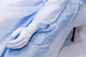 Fototapeta premium A mannequin in medical clothes lies on a table. Mannequin hand close up