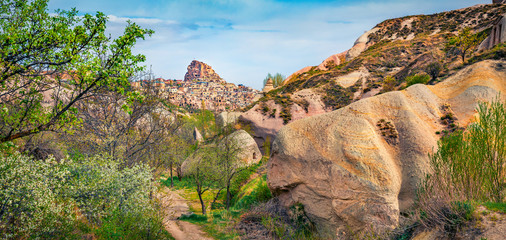 Panoramic spring view of Cappadocia. Bright outdoor scene of Uchisar Castle neighborhood....