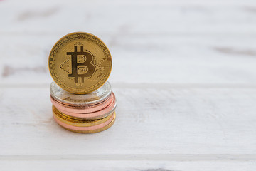 Golden bitcoin facing with stack on white background
