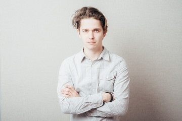 serious man with hands folded on grey background