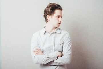 serious man with hands folded on grey background