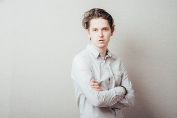 serious man with hands folded on grey background