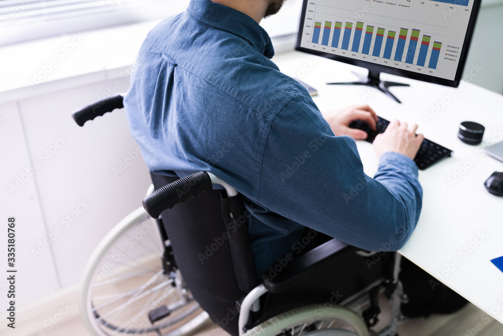 Poster businessman sitting on wheelchair and using computer