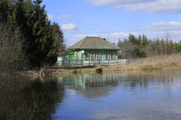 Fototapeta na wymiar Landscape with old russian house on the pond