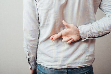 young man crossed his fingers behind his back