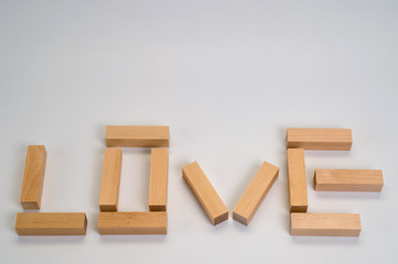 The word Love laid out by wooden blocks on a white background. Background for love and romance.