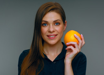 Smiling woman holding whole orange.