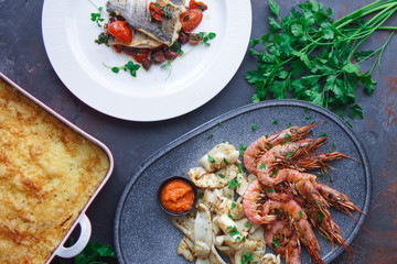 Plate with seafood, King prawns and squid, Fish menu in the restaurant, Dark background