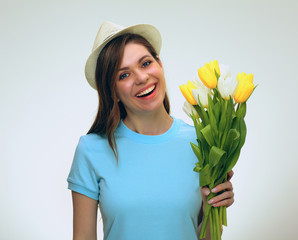 girl wearing summer hat holding yellow flowers