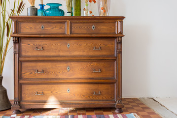 old antique old mahogany chest of drawers in a room with additional decor. interesting design - obrazy, fototapety, plakaty