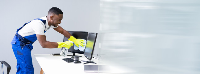 Man Cleaning Desktop Screen With Rag