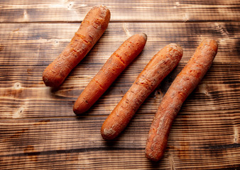 Boiled carrots lies on a wooden background.