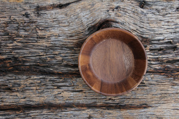 Wooden bowl on wooden background.
