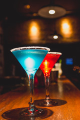 Drinks azul e vermelho no balcão
