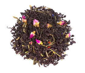 Dry black tea with pieces of dried fruit and flower petals and buds of roses isolated on white background