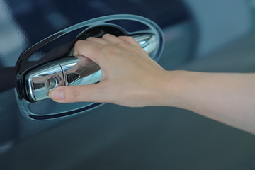 Woman hand on open the new car door