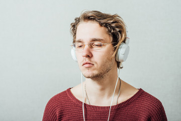 Man in headphones listening to music. On a gray background.