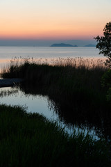 夜明けのオレンジの空と琵琶湖に流れ込む小川