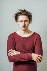 The man folded his arms on his chest. On a gray background.