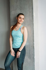 Attractive fit smiling young woman sport wear fitness girl model portrait at the home loft studio workout class