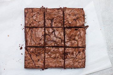 Freshly baked chocolate chewy brownie, cut into nine square pieces.