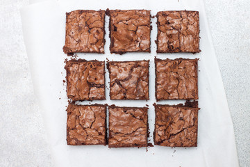 Freshly baked chocolate chewy brownie, cut into nine square pieces.