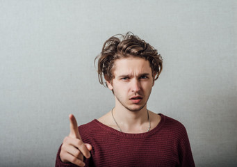 Attractive young man pressing imaginary button in the air with his finger.