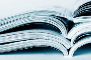 Pages of an open magazine, close-up, toning in blue. Selective focus.