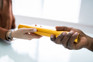 Passing Golden Relay Baton To Other Person