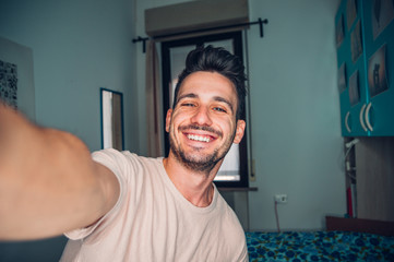 Handsome caucasian man taking a self portrait indoor at home