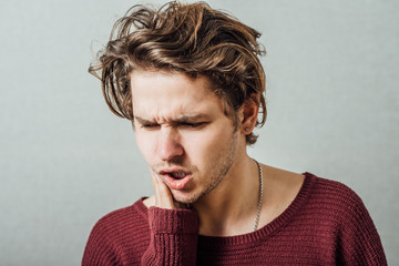 Portrait of young man with toothache