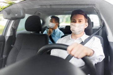 health protection, safety and pandemic concept - male taxi driver wearing face protective medical mask driving car with passenger - obrazy, fototapety, plakaty